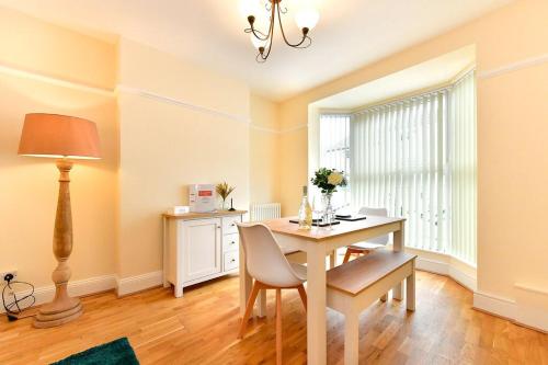 comedor con mesa y lámpara en Castle Square Cottage - Beachside Retreat, en Mumbles