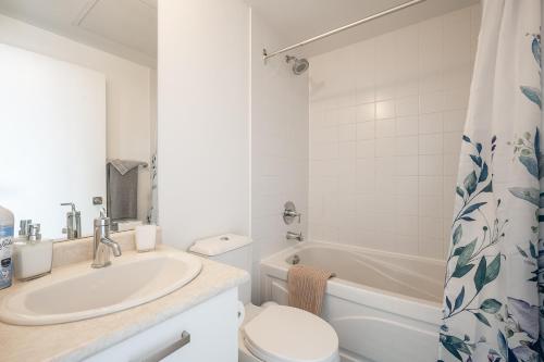 a bathroom with a sink and a toilet and a tub at 1BR High Floor View Downtown Toronto in Toronto