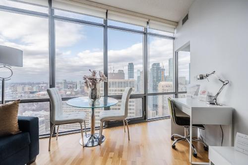 a room with a table and chairs and a large window at 1BR High Floor View Downtown Toronto in Toronto