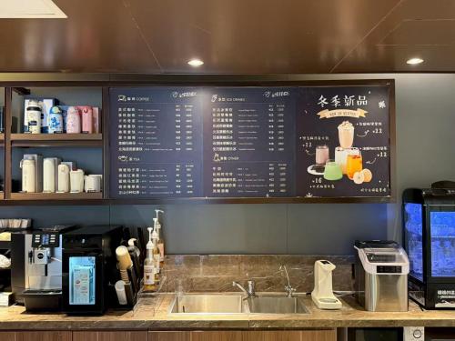 a kitchen with a sink and a menu on the wall at Hanting Hotel Beijing Wudaokou Tsinghua Park in Beijing