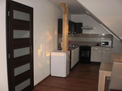a kitchen with a staircase leading into a kitchen with a refrigerator at Apartmány Eva Frymburk in Frymburk