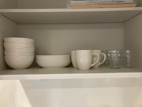 a shelf with bowls and cups on it at PRISM Inn Tateishi in Tokyo