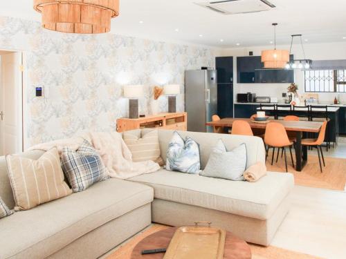 a living room with a couch and a kitchen at Crane Song Cottage-Solar Power in Himeville