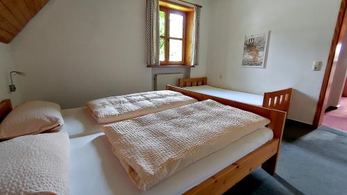 two beds in a small room with a window at FerienFleckl in Warmensteinach