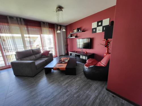 a red living room with a couch and a table at Apartemento Cerveira in Vila Nova de Cerveira
