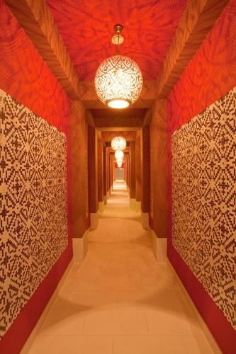 a hallway with red walls and a chandelier at Hotel Maximilian’s in Augsburg