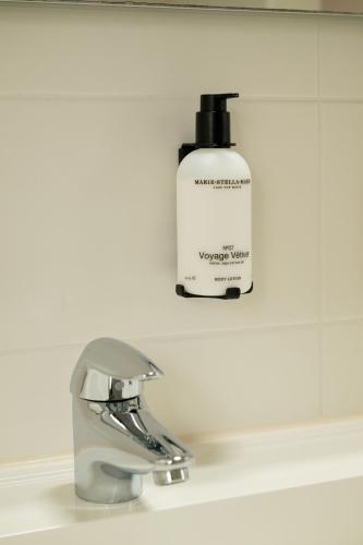 a bathroom sink with a bottle of shampoo next to a faucet at Vlierijck in Oost-Vlieland