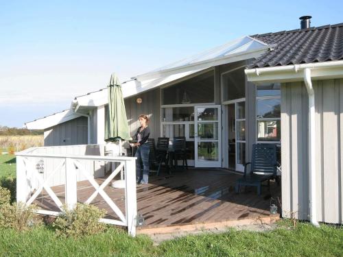 a woman standing on a wooden deck on a house at Luxury Beach Retreat - By Traum Ferienwohnungen in Rude