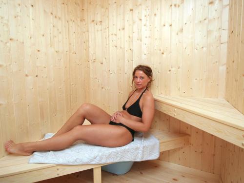 a woman is sitting in a sauna at Luxury Beach Retreat - By Traum Ferienwohnungen in Rude