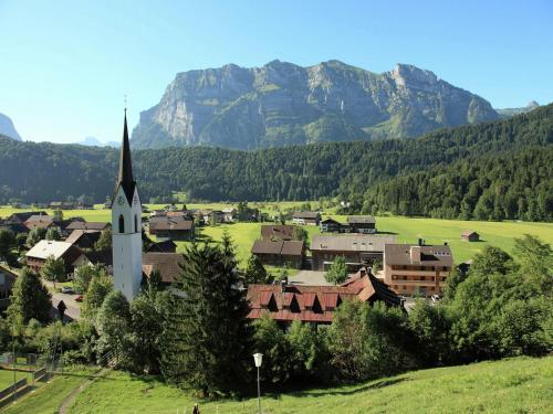 a small town with a church and mountains in the background at Chalet in Sibratsgfäll near Ski Slopes in Sibratsgfäll