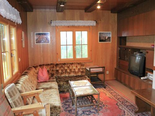 a living room with a couch and a tv at Chalet in Sibratsgfäll near Ski Slopes in Sibratsgfäll