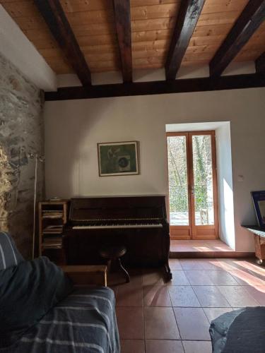 a living room with a piano in a room at Molino di Carpenosa in Molini di Triora