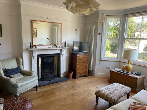 a living room with a fireplace and a television at Central Sevenoaks townhouse in Sevenoaks