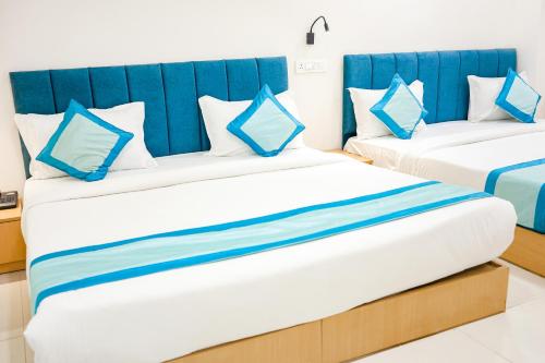 two beds in a room with blue and white at Hotel Konark Nest-Vijay Nagar in Indore