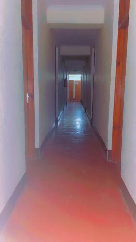 an empty hallway with a red floor in a building at Kyanga Hostel in Arusha