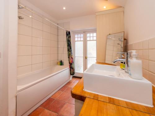 a bathroom with a tub and a sink and a bath tub at Central Caversham Traditional English House Pass the Keys in Reading