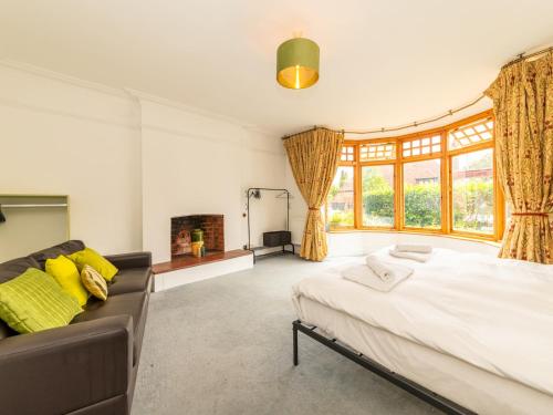a bedroom with a large bed and a couch at Central Caversham Traditional English House Pass the Keys in Reading