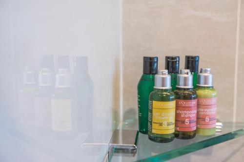 three bottles of oils sitting on a glass shelf at Zenith Hotel Putrajaya in Putrajaya