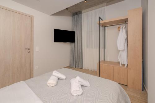 a bedroom with a bed with white towels on it at Dear Paris Apartment in Piraeus