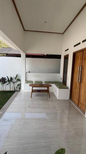 a patio with a wooden bench and a table at Ameni Villa in Kuta Lombok