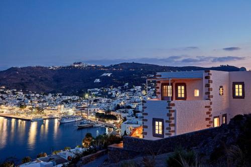 a house with a view of a harbor at night at Patmos Eye Boutique Hotel & Villas in Skala
