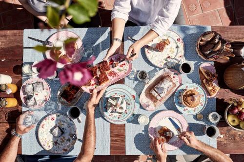 a group of people sitting around a table eating food at Patmos Eye Boutique Hotel & Villas in Skala