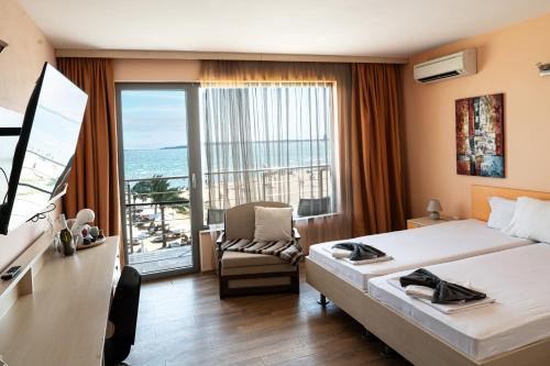 a hotel room with a bed and a desk and a window at Sunny Beach Vila in Sunny Beach