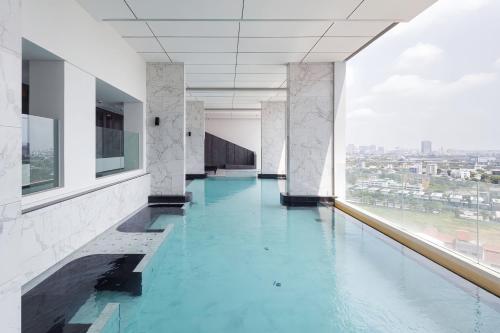 a swimming pool with blue water in a building at Siamese Residence Rama 9 Bangkok in Bangkok