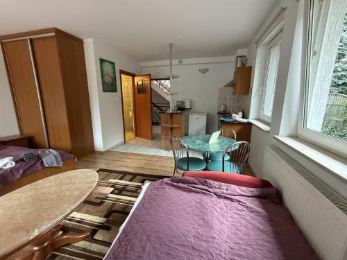 a living room with a table and a kitchen at VITA Augustów in Augustów