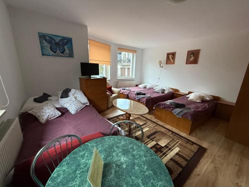 a room with two beds and a table in it at VITA Augustów in Augustów