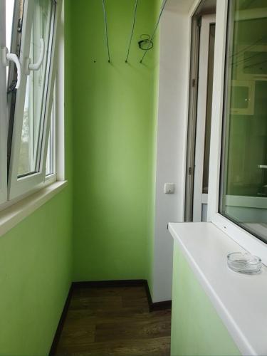 a green room with a white counter and a window at Квартира in Bilhorod-Dnistrovskyi