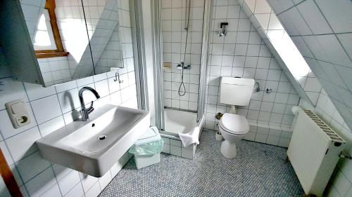 a white bathroom with a sink and a toilet at FerienFleckl in Warmensteinach