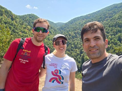 two men and a woman standing in front of a mountain at Sim Guesthouse in Sım