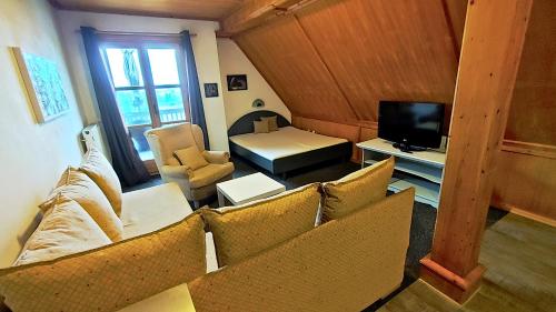 a living room with a couch and chairs and a television at FerienFleckl in Warmensteinach
