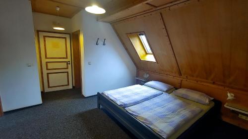 a bedroom with a bed with a wooden wall and a window at FerienFleckl in Warmensteinach