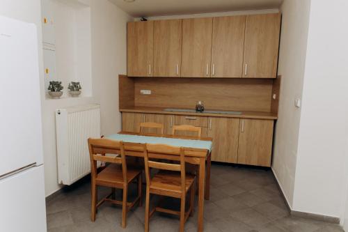 a kitchen with a table and some wooden cabinets at Sleep & Go Czech Republic - Praha 5 Anděl in Prague