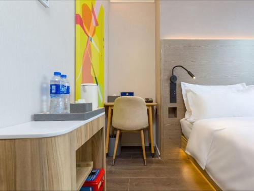 a hotel room with a bed and a desk with a chair at Hanting Hotel Beijing Wudaokou Tsinghua Park in Beijing