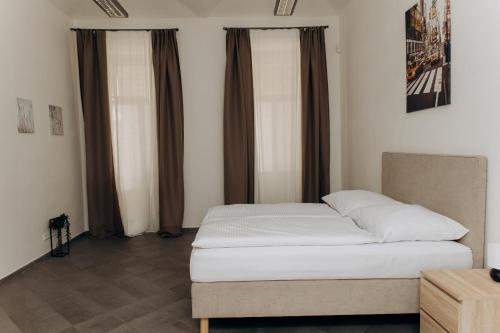 a bed sitting in a room with brown curtains at Sleep & Go Czech Republic - Praha 5 Anděl in Prague