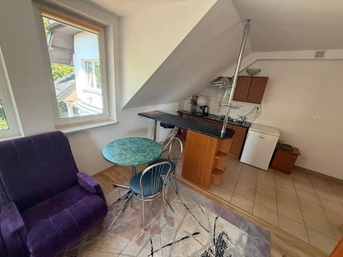 a living room with a purple couch and a kitchen at VITA Augustów in Augustów