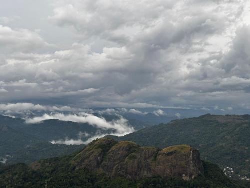 a view of a mountain under a cloudy sky at Cloud Hills Munnar in Kallar Vattiyar