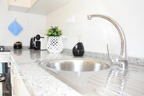 a kitchen counter with a stainless steel sink at Ericeira Apartments in Ericeira