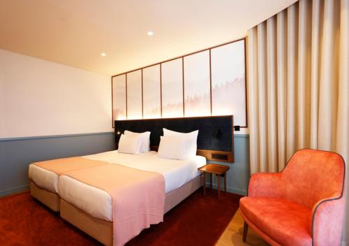 a hotel room with a bed and a chair at Montebelo Viseu Congress Hotel & Spa in Viseu