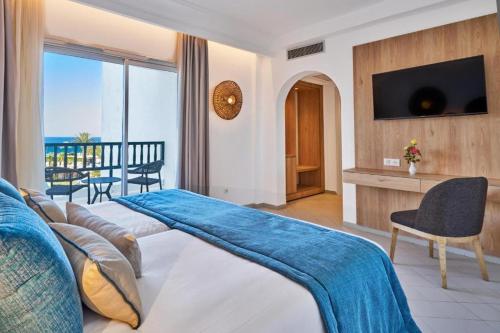 a hotel room with a bed and a view of the ocean at Hotel El Mansour Mahdia Thalasso & Spa in Mahdia