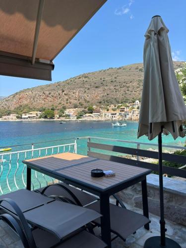 an umbrella sitting on a table next to the water at Limeni koilakos Suite in Limeni