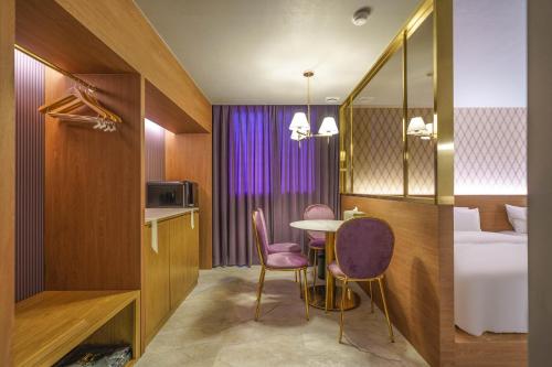 a hotel room with a table and chairs and a bed at Yongin IPPDA Petite in Yongin