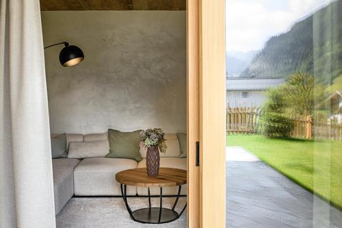 a door to a living room with a couch and a table at Naturhof eibl in Grossarl