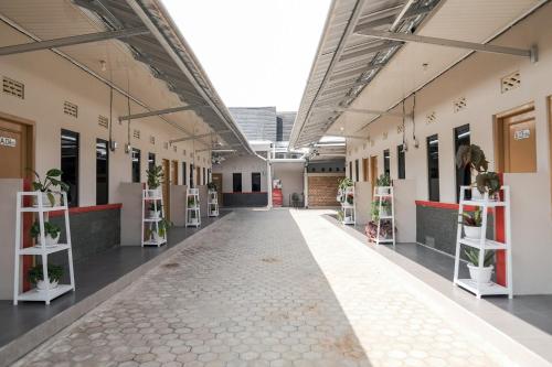 an empty corridor of a building with potted plants at RedDoorz Syariah near Hajimena Lampung in Lampung