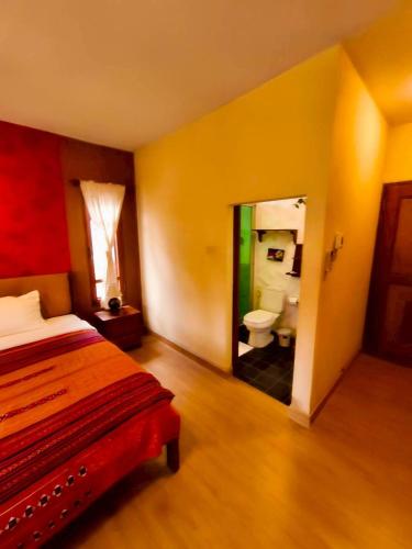 a bedroom with a bed and a bathroom with a toilet at Plumeriahome near Chiangmai Airport in Chiang Mai