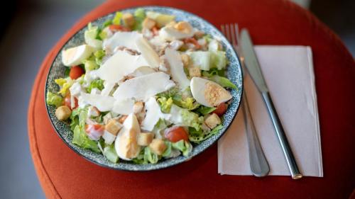 a salad in a bowl on a red table at Hotel Indigo Brussels - City by IHG in Brussels