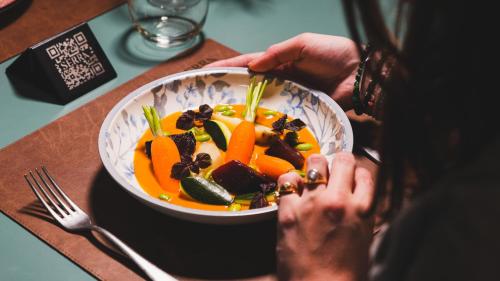 a person sitting at a table with a bowl of food at Hotel Indigo Brussels - City by IHG in Brussels